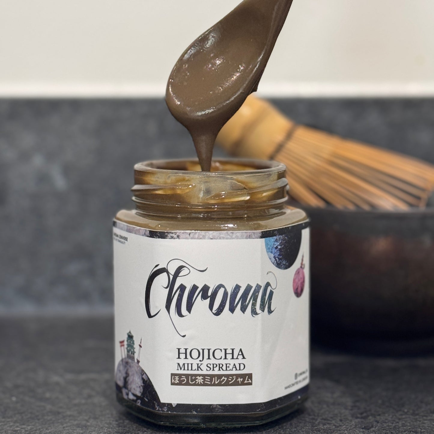 Jar of Hojicha Milk Spread with a spoonful being lifted